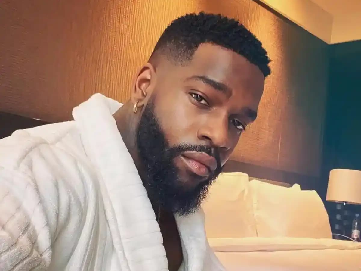 Tayc performing on stage with vibrant lighting and an enthusiastic crowd.