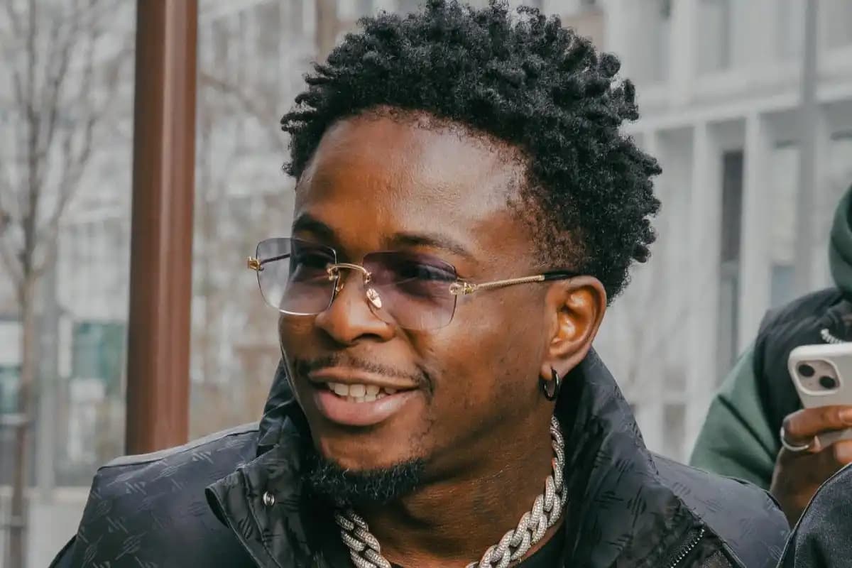 Didi B performing on stage with vibrant lights and an enthusiastic crowd.