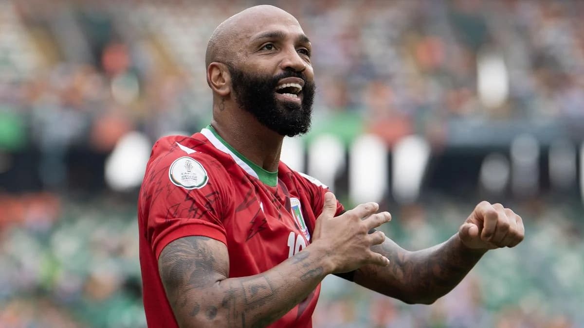Emilio Nsue in a football jersey, smiling on the field during a match.