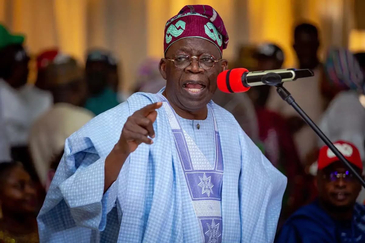 Nigerian President Bola Ahmed Tinubu speaking during a rally in Abuja. Dressed in traditional agbada attire, he passionately defends his political vision amid growing criticism.