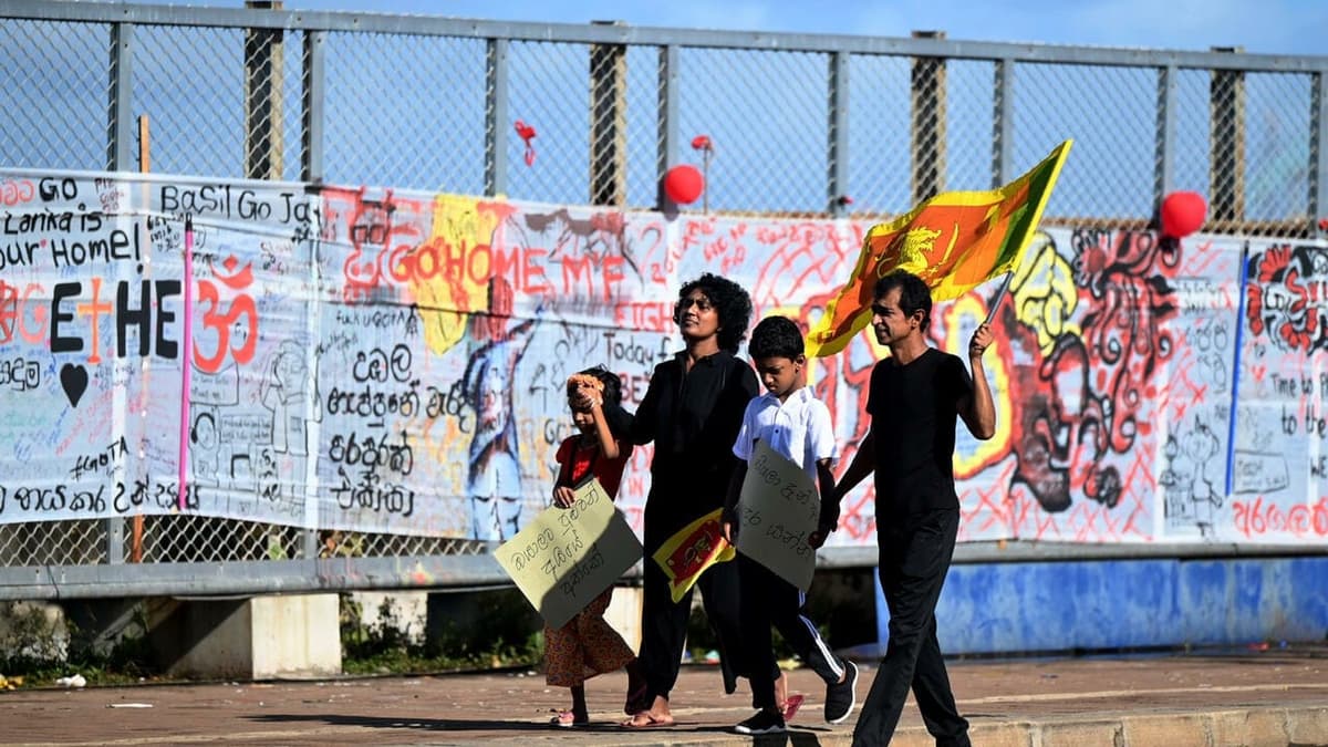 Une famille marche lors des célébrations du Nouvel An à Colombo, entourée de manifestants devant le bureau du président.