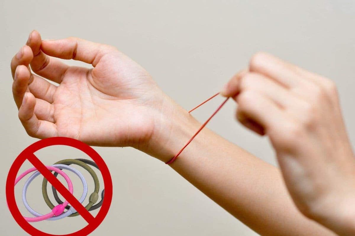 une main entrai de tirer une élastique au poignet d'une autre