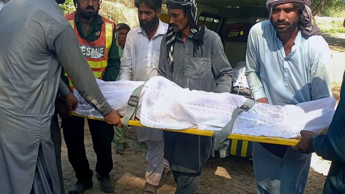 Un secouriste et des villageois portent le corps d'une victime d'un accident de bateau sur le fleuve Indus, dans le district de Sadiqabad, Ã  environ 350 kilomètres (210 miles) au sud de Multan, au Pakistan, lundi 18 juillet 2022.