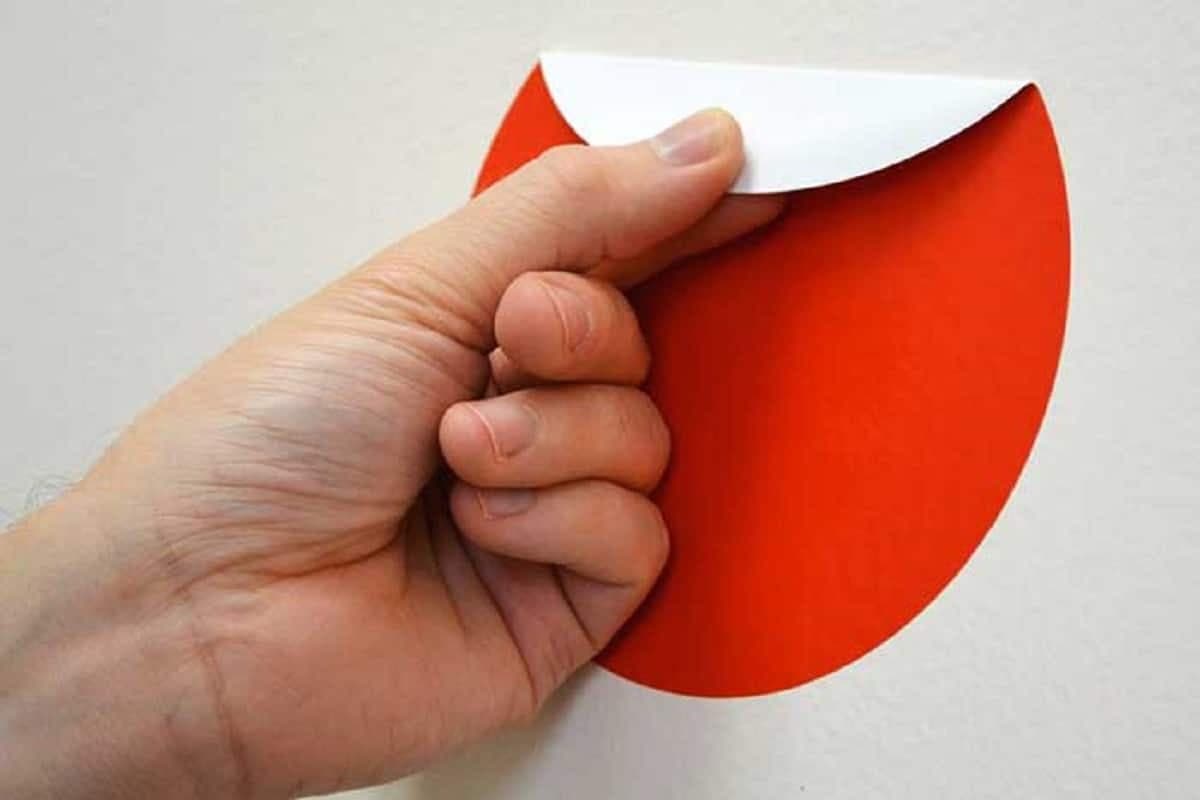 une main en train d'enlever un autocollant