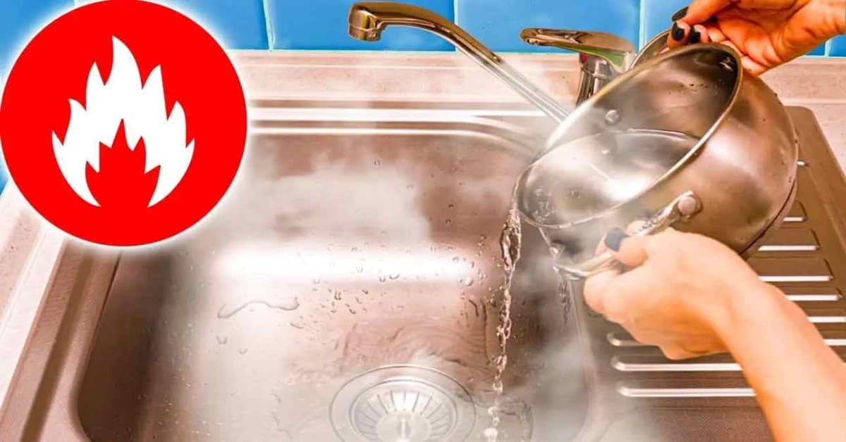 une main en train de verser de l'eau bouillante dans un évier