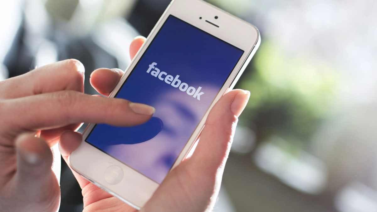 des mains tenant de smartphone avec l'appellation facebook
