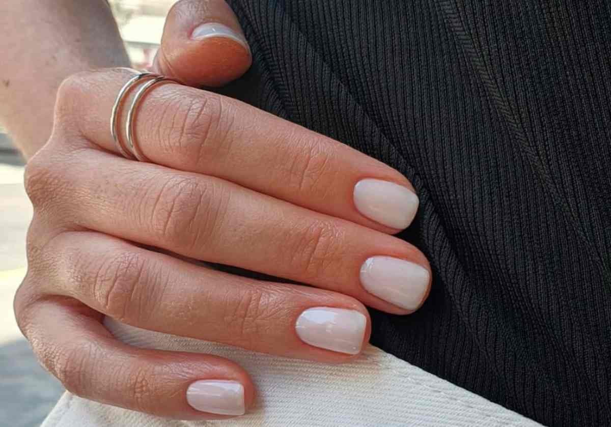 une main avec de jolis et longs ongles et aussi avec une bague au majeur