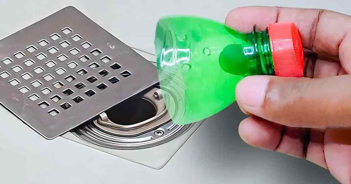 un drain de douche ouverte avec une bouteille en plastique de couleur verte coupée