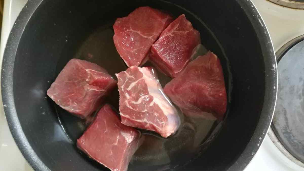 des morceaux de viande coupés en dés dans une casserole