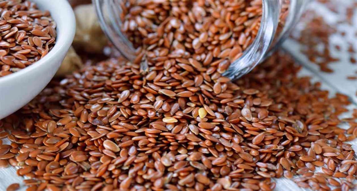 Des graines de Lin dans une tasse, mais aussi dans une bouteille et sur une table