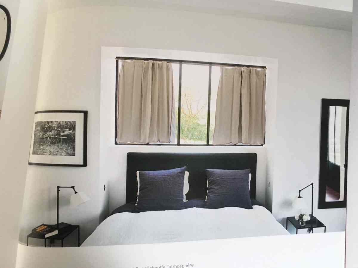 un lit sous une fenêtre