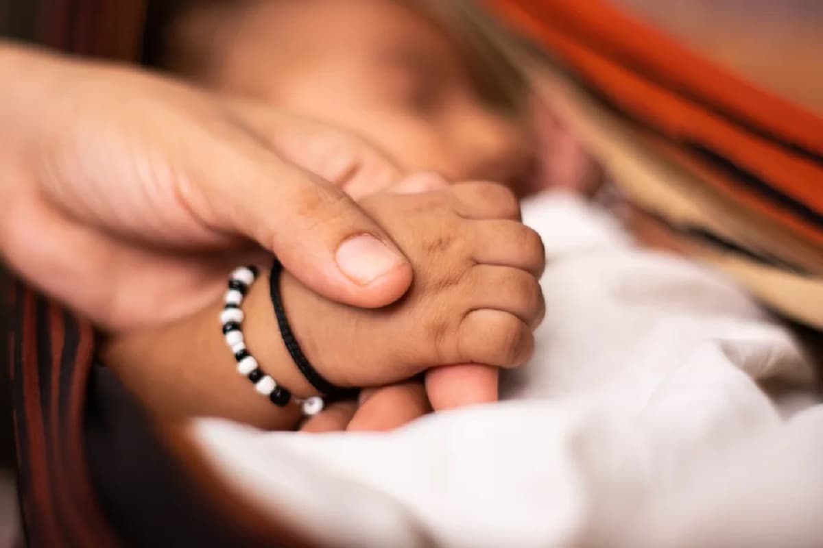 A newborn baby holding the parent hand while sleeping at cradle. (lakshmiprasad S via Getty Images)