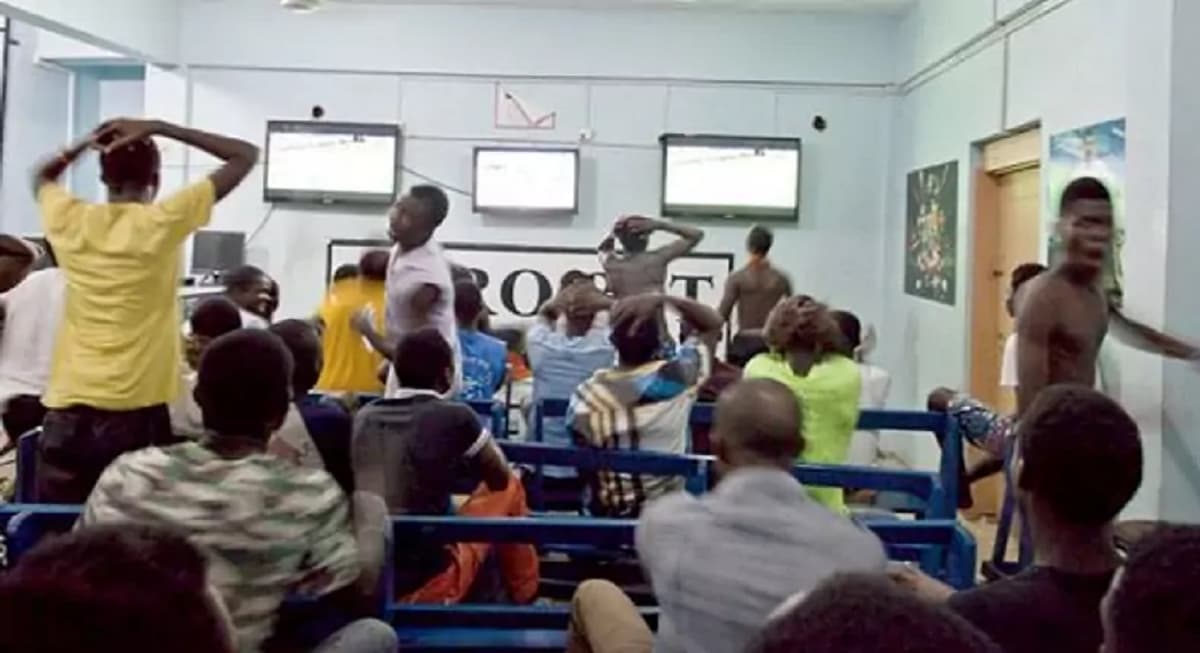 Centre de pari sportif avec des écrans affichant des cotes et des événements sportifs.