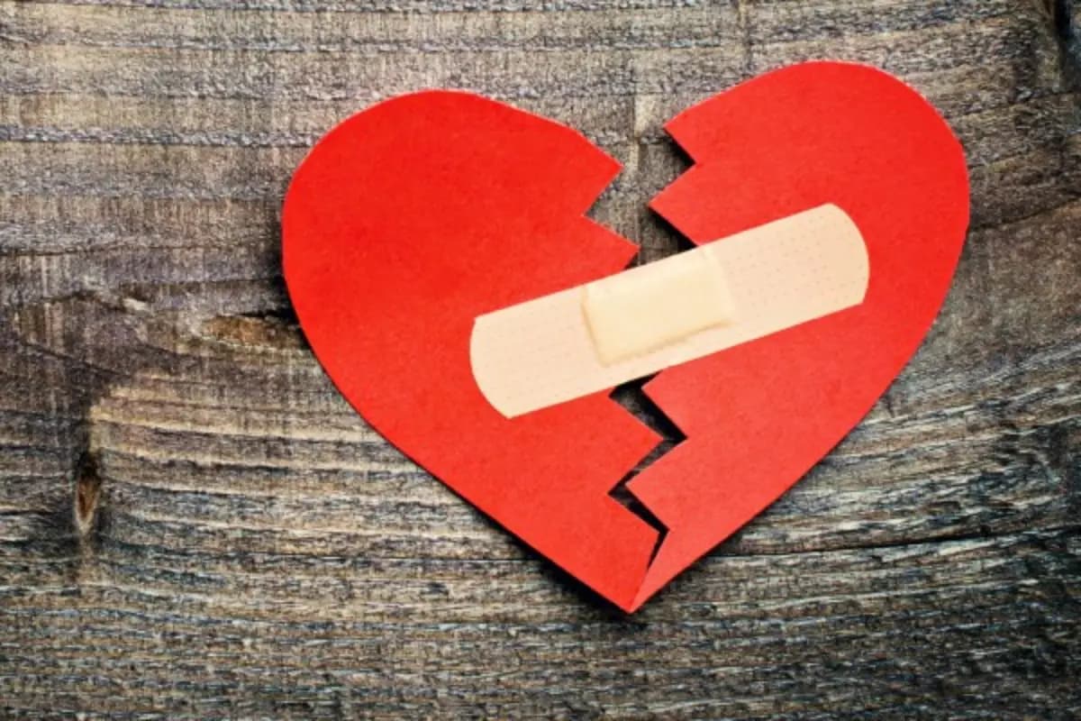 Cœur réparé symbolisant la réconciliation amoureuse, avec des éléments astrologiques en arrière-plan.