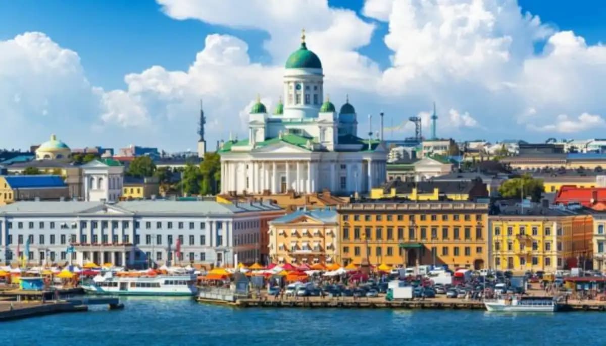 Paysage finlandais avec des forêts verdoyantes et un ciel bleu, symbole de bonheur et de sérénité.