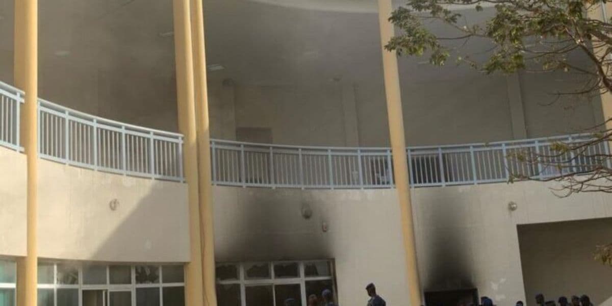 Tribunal de Dakar en flammes suite à une explosion de gaz, fumée noire s'élevant dans le ciel.