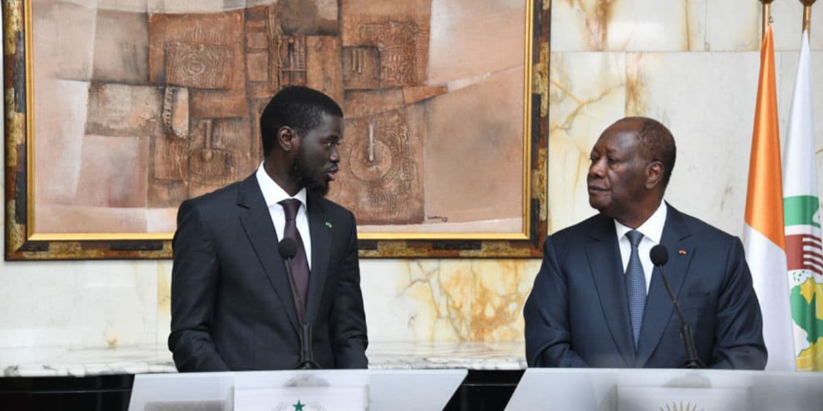 Alassane Ouattara et Diomaye Faye en discussion, affichant une entente diplomatique.
