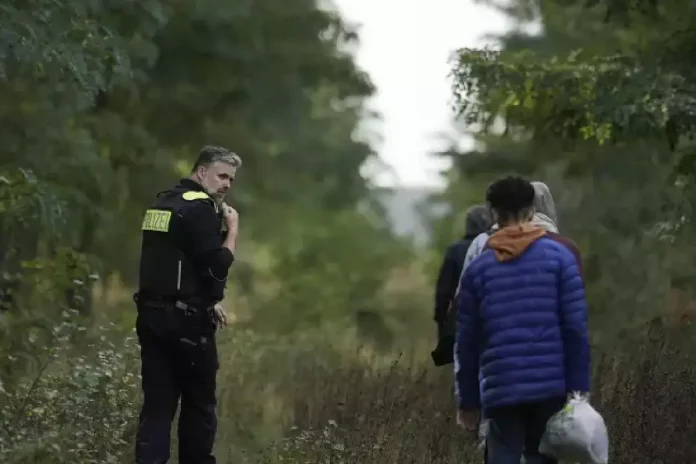 Un policier allemand escorte un groupe de migrants illégaux @Sipa Press